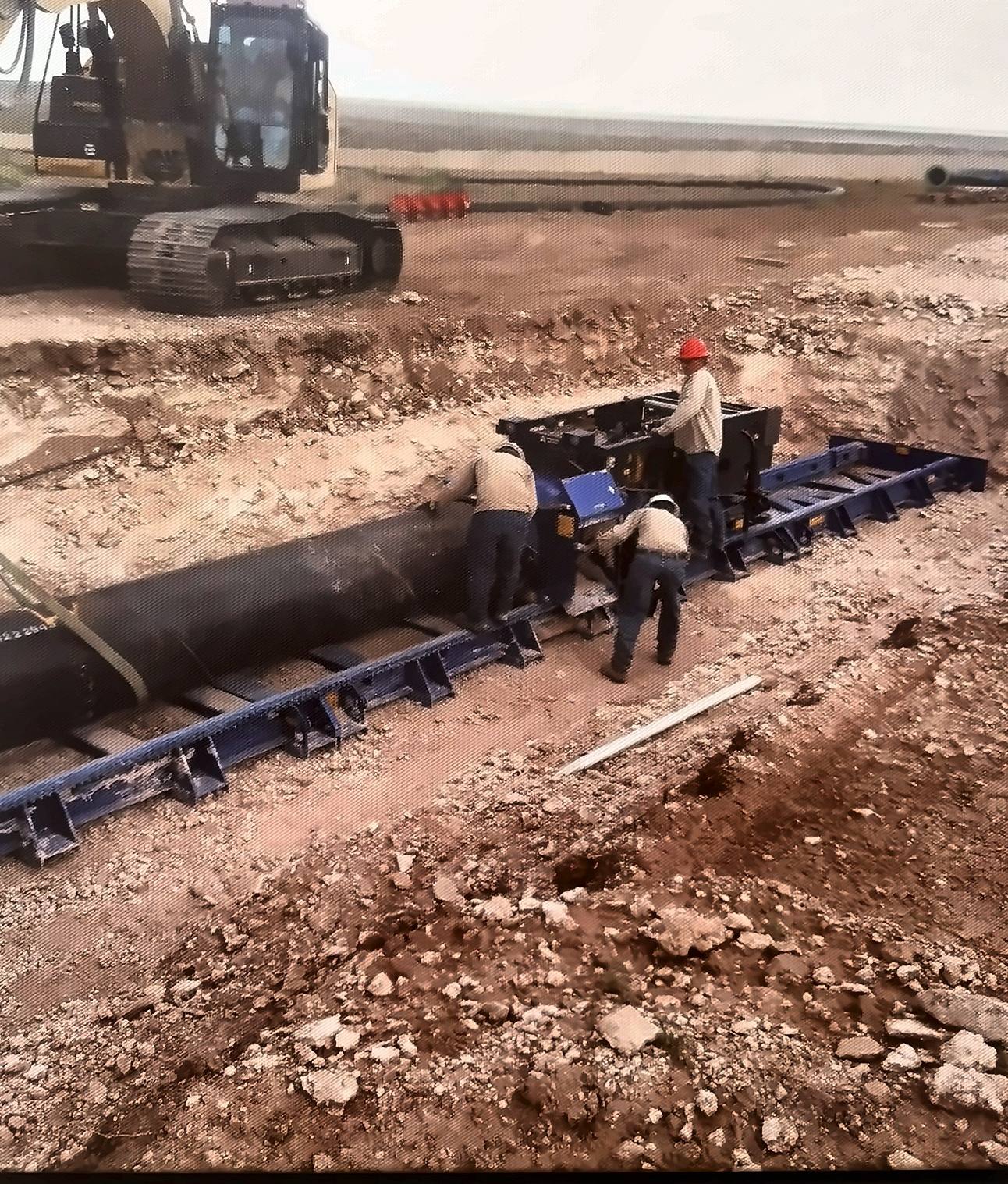 Encore crew setting up an auger boring machine with steel casing in a bore pit